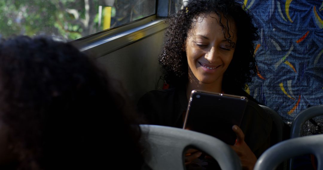 Woman Smiling While Using Tablet on Bus - Free Images, Stock Photos and Pictures on Pikwizard.com