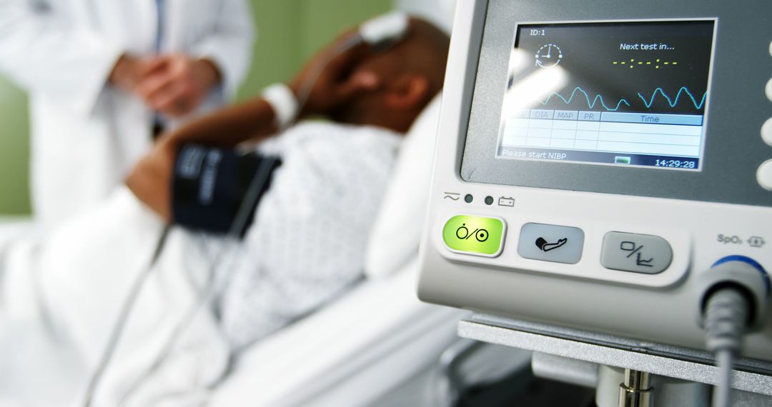 Doctor Treating Patient in Hospital Bed Next to Medical Monitor - Free Images, Stock Photos and Pictures on Pikwizard.com