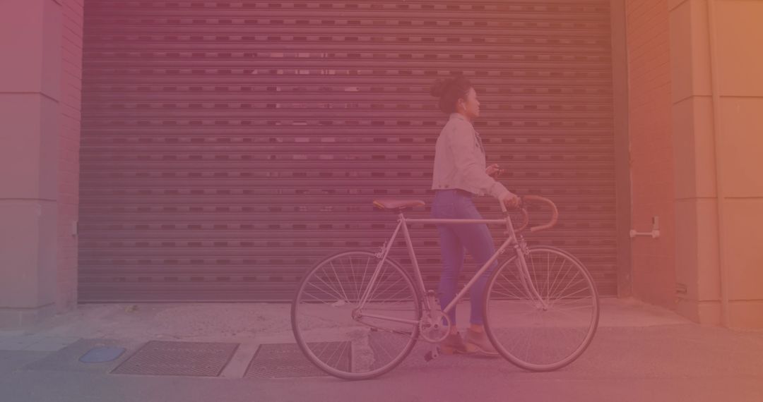 Woman with Bicycle Uses Smartphone While Walking on Urban Street