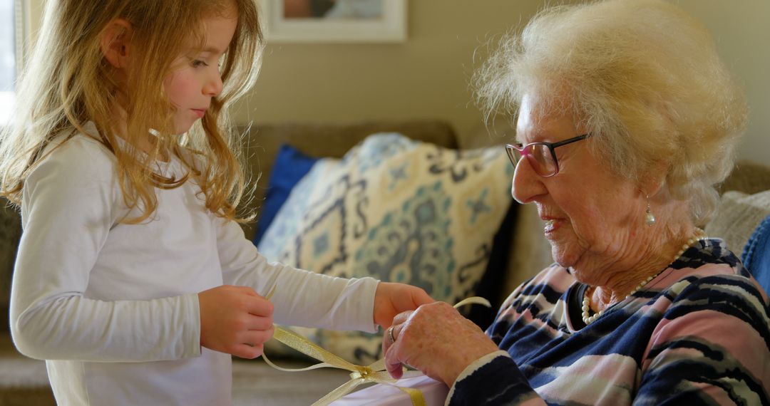 Young Girl Helping Elderly Woman with Gift Wrapping - Free Images, Stock Photos and Pictures on Pikwizard.com