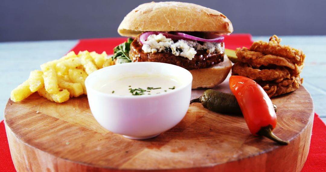 Gourmet Burger with Salad, Onion Rings, and Dipping Sauce on Wooden Board - Free Images, Stock Photos and Pictures on Pikwizard.com