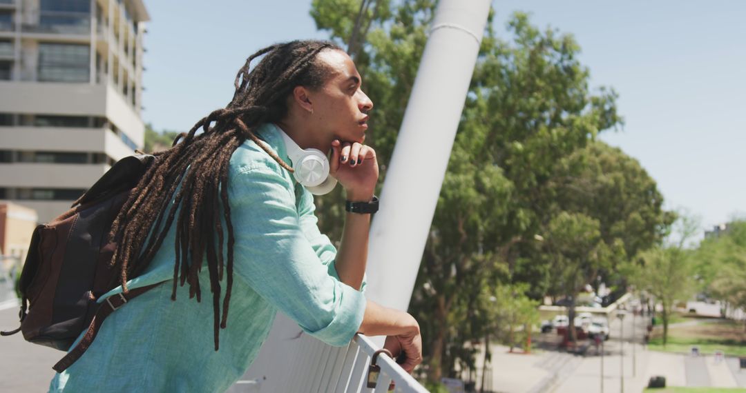 Young Person with Dreadlocks Relaxing Outdoors with Headphones - Free Images, Stock Photos and Pictures on Pikwizard.com