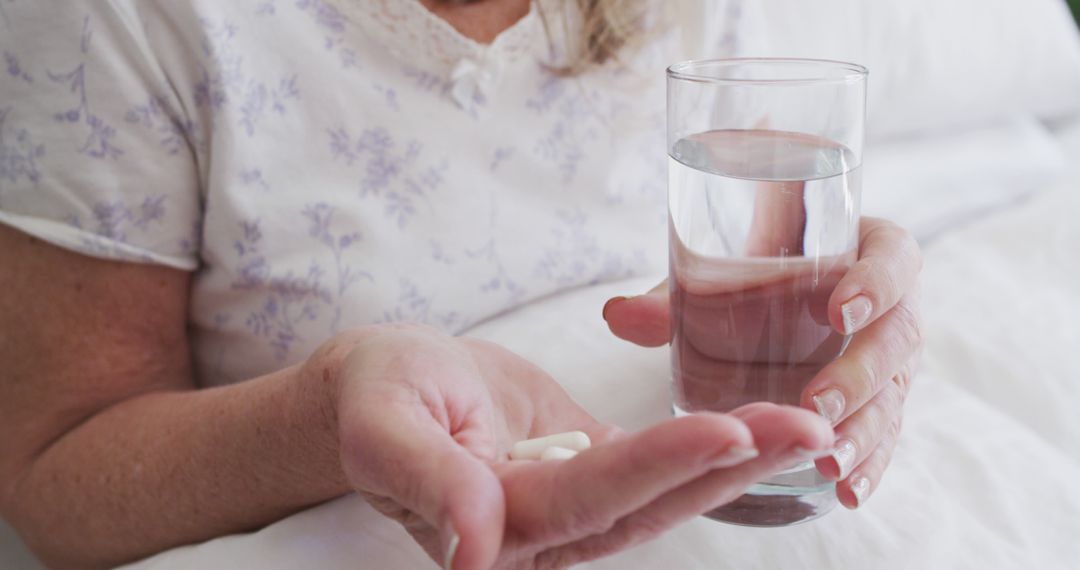 Senior Woman Holding Medication and Glass of Water - Free Images, Stock Photos and Pictures on Pikwizard.com