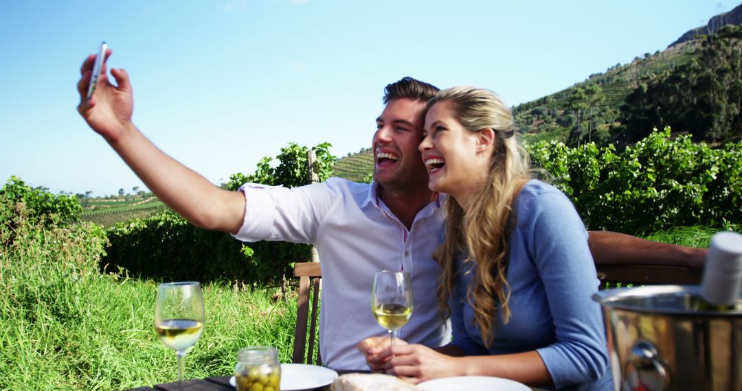 A couple joyfully snaps a selfie during an outdoor wine tasting at a vineyard. - Free Images, Stock Photos and Pictures on Pikwizard.com