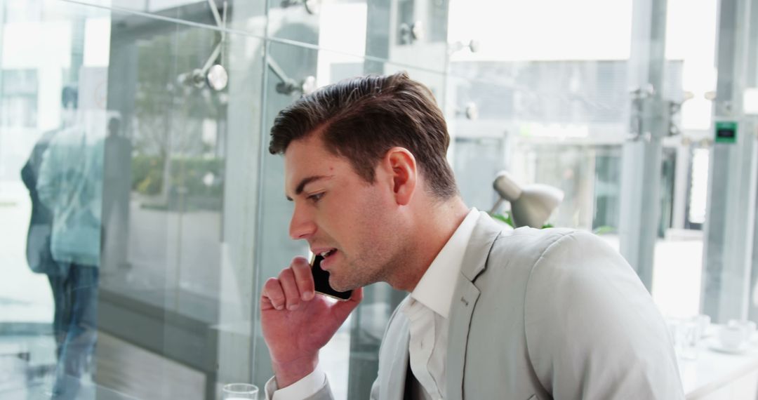 Businessman Engaged in Phone Call in Modern Office - Free Images, Stock Photos and Pictures on Pikwizard.com