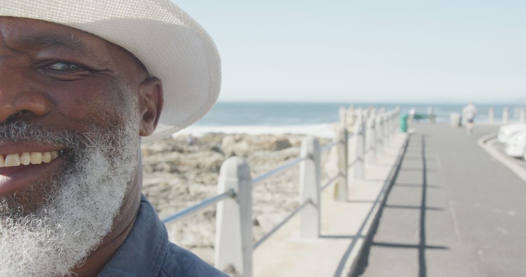 Cheerful Senior Man Enjoying Sunny Day on Oceanside Boardwalk - Free Images, Stock Photos and Pictures on Pikwizard.com