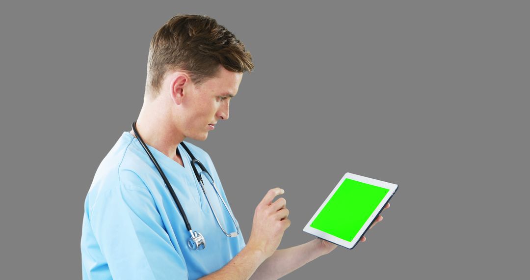 Male Doctor in Scrubs Using Digital Tablet with Green Screen - Free Images, Stock Photos and Pictures on Pikwizard.com