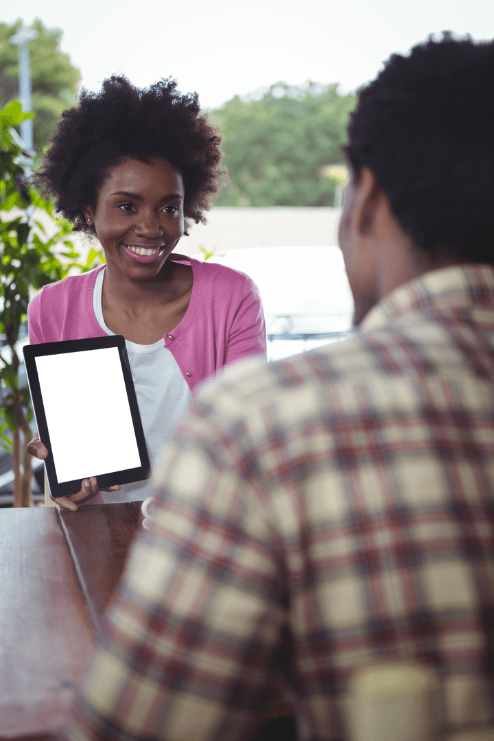Smiling Young Woman Presenting Transparent Tablet at Cafe