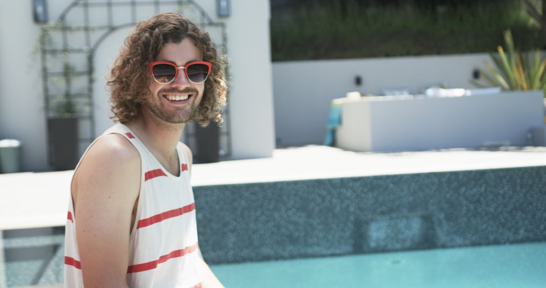 Smiling Young Man Enjoying Leisure by Poolside in Summer