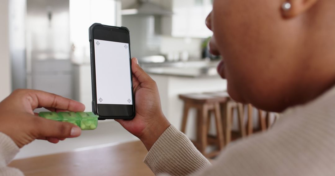 Woman Using Smartphone with Medication in Hand at Home - Free Images, Stock Photos and Pictures on Pikwizard.com