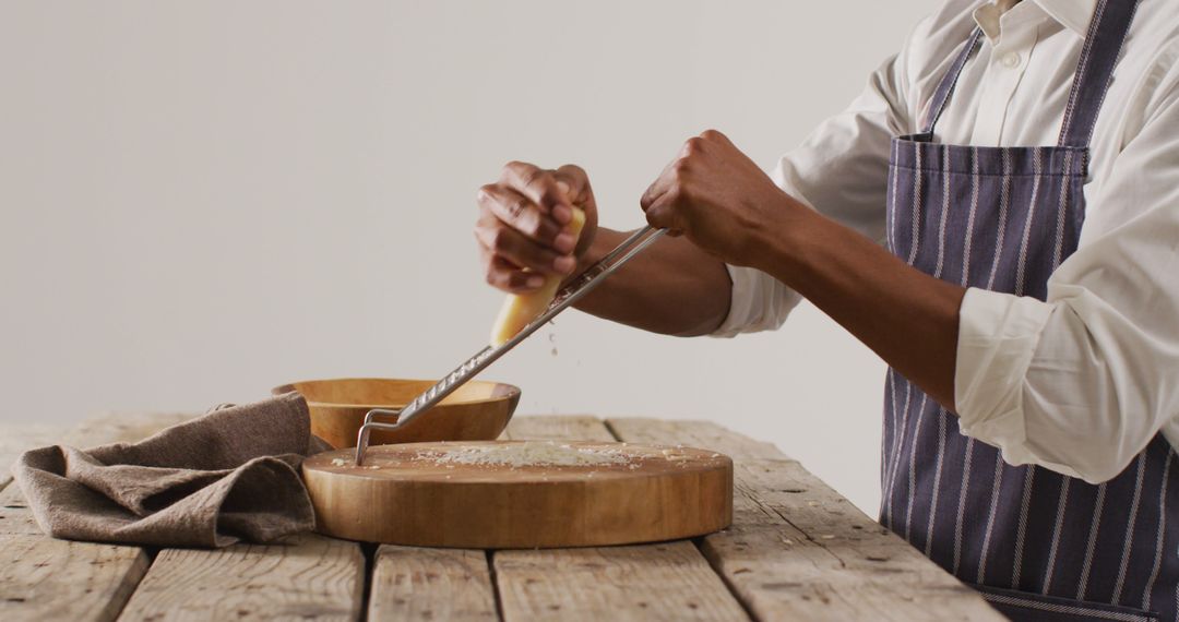 Chef Grating Cheese Over Wooden Cutting Board - Free Images, Stock Photos and Pictures on Pikwizard.com