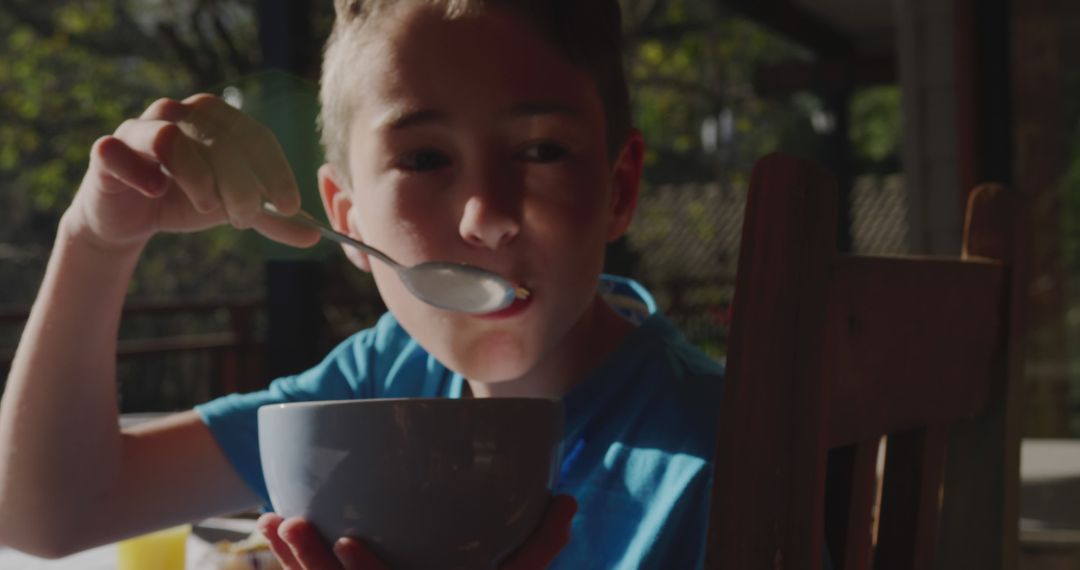 Young Boy Eating Breakfast Outdoors During Morning - Free Images, Stock Photos and Pictures on Pikwizard.com