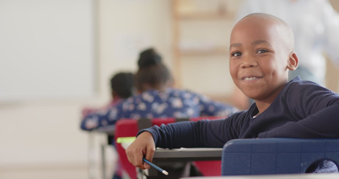Smiling African American Boy Holding Pencil in Classroom Setting
