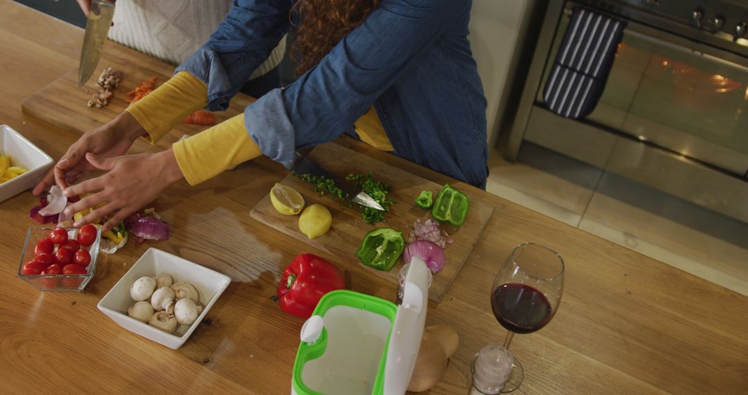 Image of happy biracial couple preparing meal together and drink wine - Free Images, Stock Photos and Pictures on Pikwizard.com