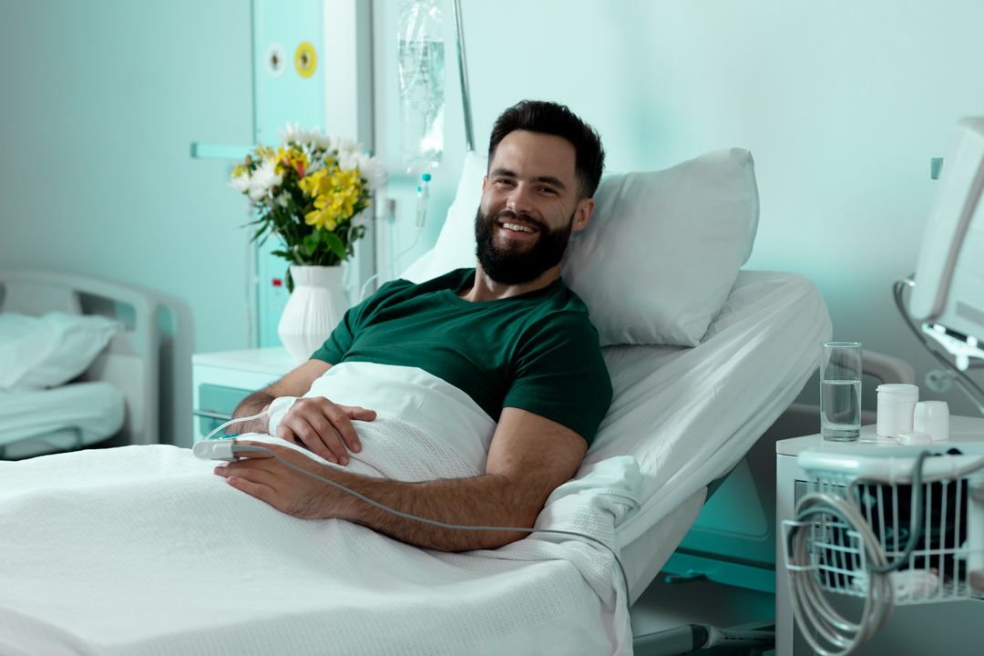 Portrait of bearded caucasian male patient sitting up in hospital bed smiling - Free Images, Stock Photos and Pictures on Pikwizard.com
