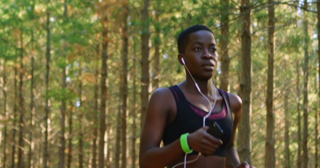 Woman Jogging with Earphones in Forest - Free Images, Stock Photos and Pictures on Pikwizard.com