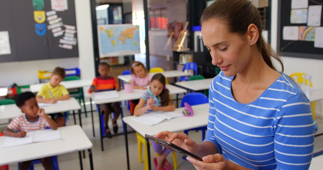 Teacher Using Digital Tablet in Classroom with Attentive Schoolchildren