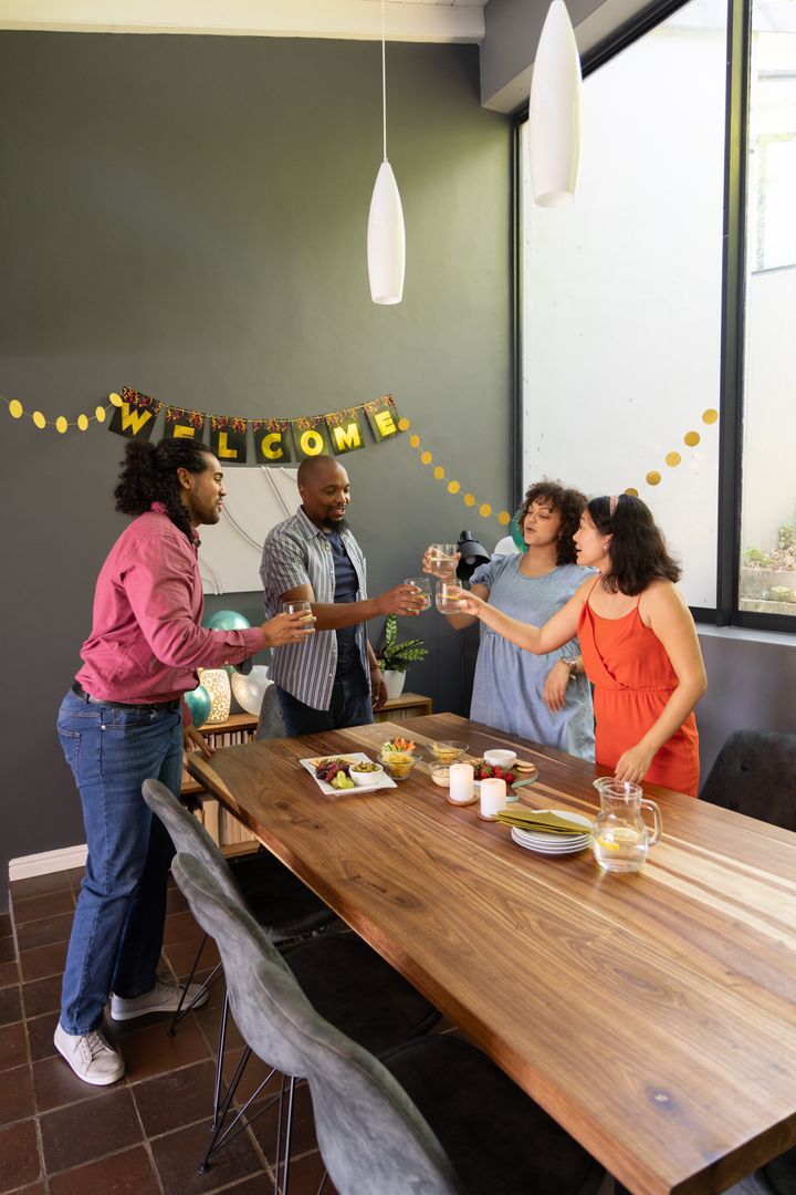 Diverse Friends Toasting Around Dining Table in Modern Home