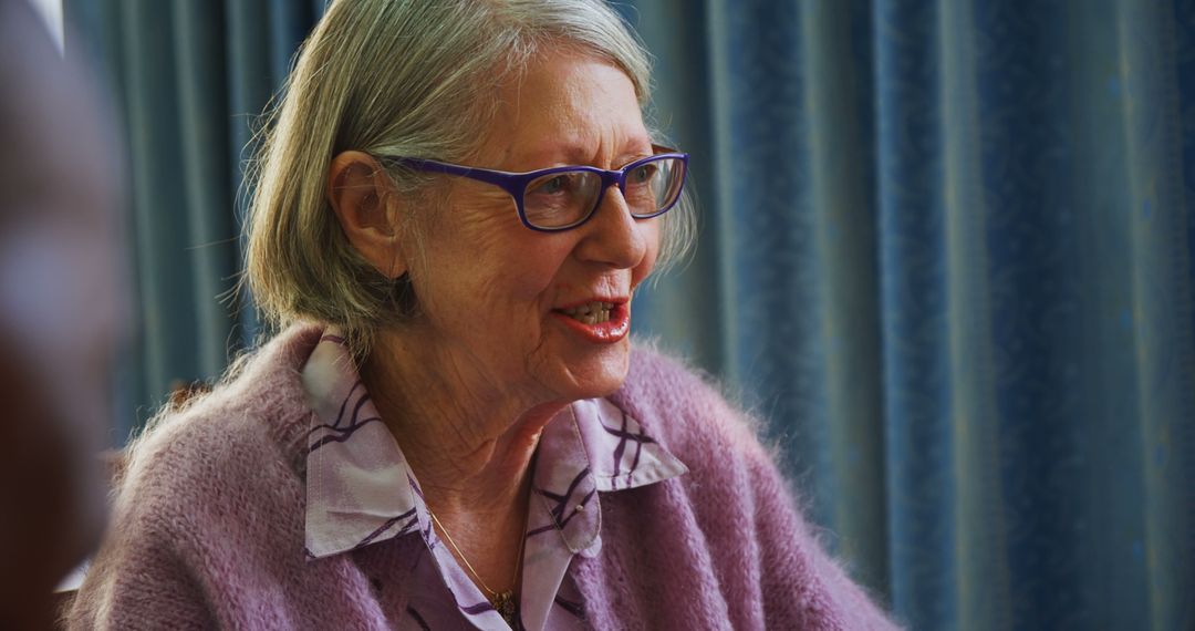 A joyful senior woman in a pink cardigan smiles with glasses, implying a happy moment. - Free Images, Stock Photos and Pictures on Pikwizard.com