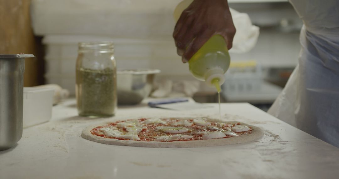 Hands Preparing Homemade Pizza with Olive Oil in Kitchen - Free Images, Stock Photos and Pictures on Pikwizard.com