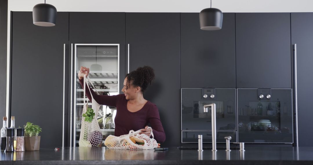 Woman Organizing Groceries in Modern Kitchen with Black Cabinets - Free Images, Stock Photos and Pictures on Pikwizard.com