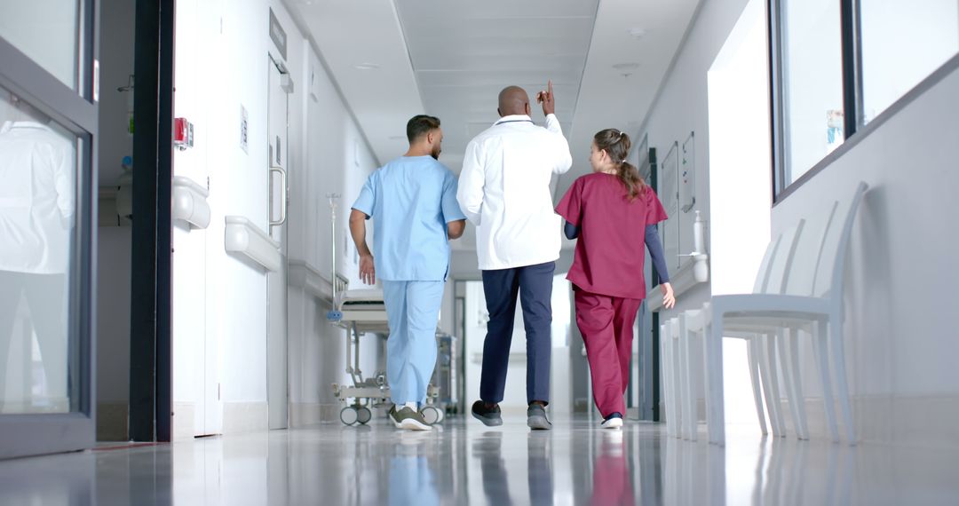 Medical Team Walking Down Hospital Corridor in Scrubs - Free Images, Stock Photos and Pictures on Pikwizard.com