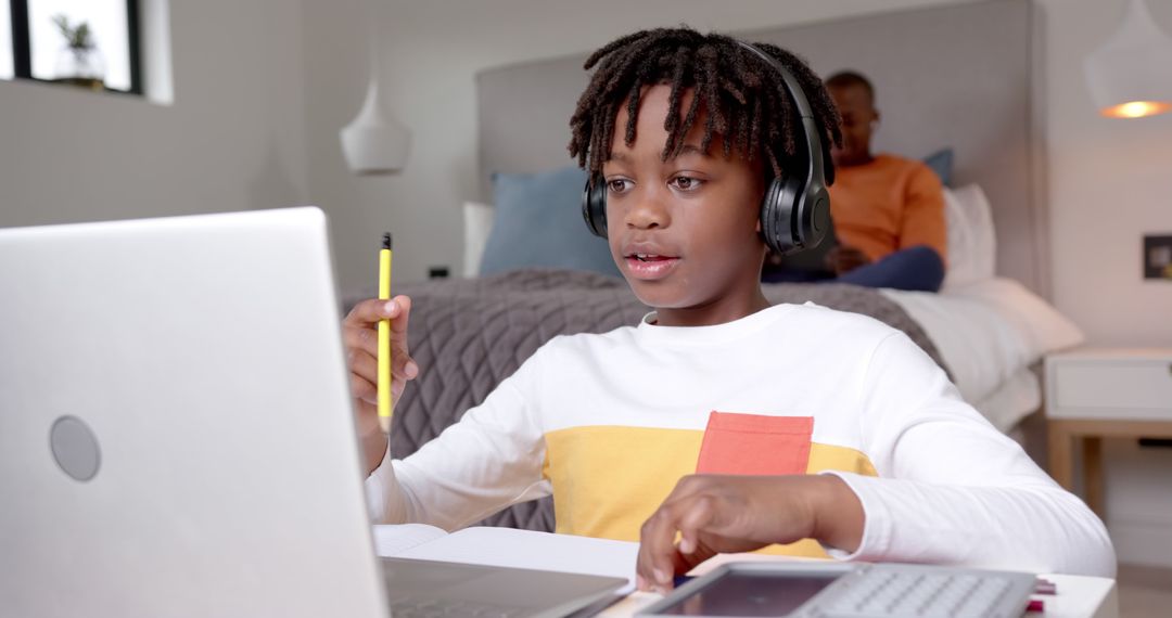 African American Boy Using Laptop at Home, Wearing Headphones for Online Learning - Free Images, Stock Photos and Pictures on Pikwizard.com