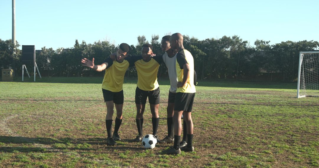 Football Players Strategizing on Field Before Match