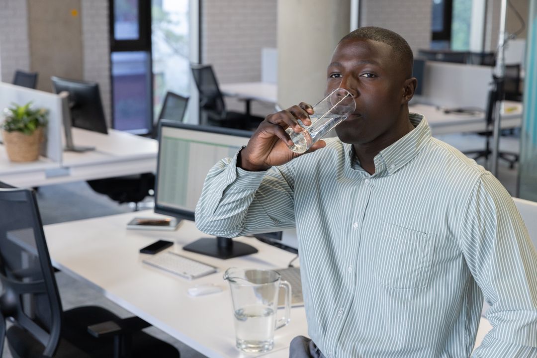 Professional Man Drinking Water at Contemporary Office Workspace