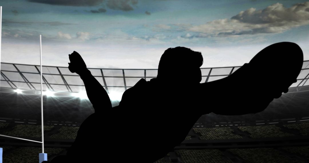 Silhouette of Rugby Player Reaching for Ball at Stadium