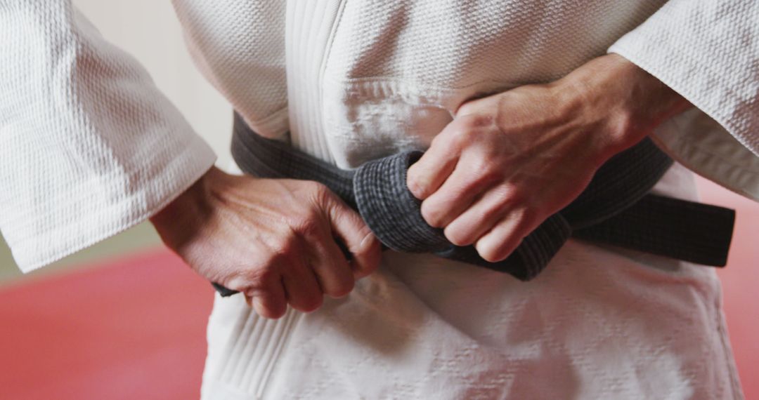 Martial Artist Tying Black Belt on Gi Uniform - Free Images, Stock Photos and Pictures on Pikwizard.com