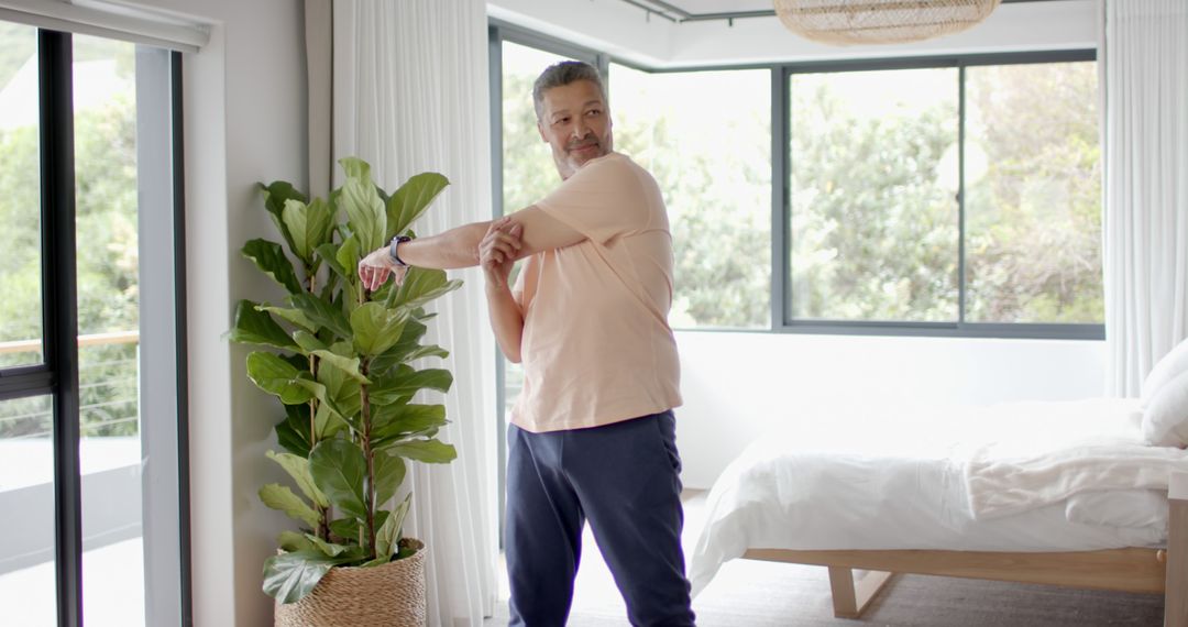 Mature Man Stretching Arm in Modern Bedroom - Free Images, Stock Photos and Pictures on Pikwizard.com