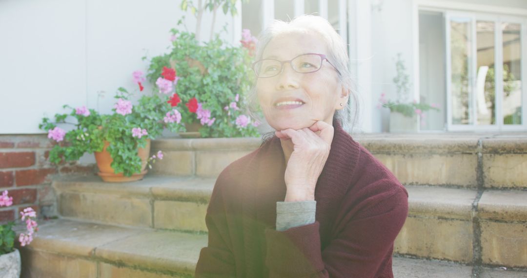 Smiling Elderly Woman Relaxing in Sunlit Garden - Free Images, Stock Photos and Pictures on Pikwizard.com