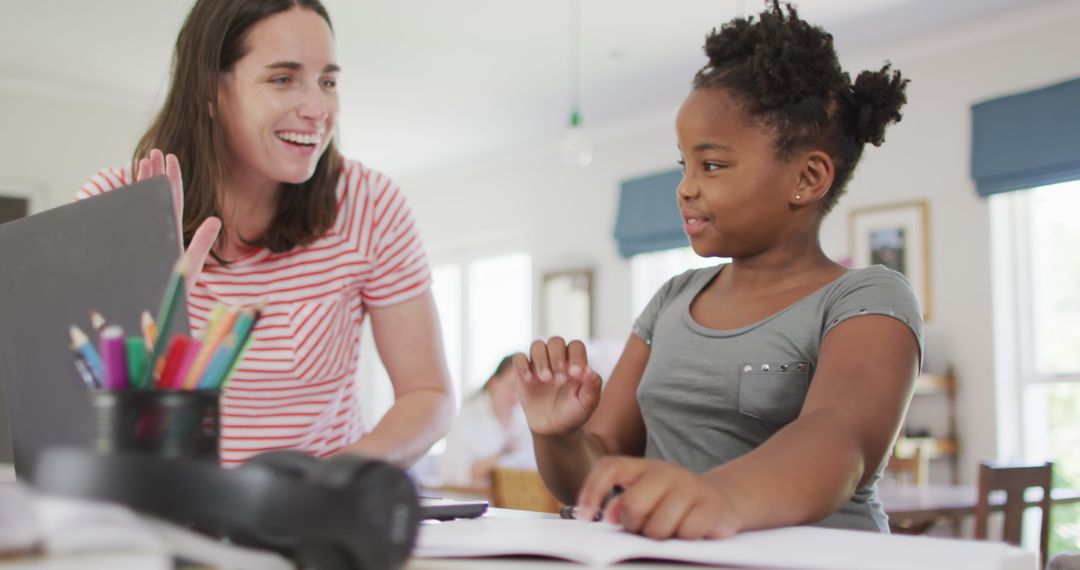 Happy Mother Helping Daughter with Homework Home Education