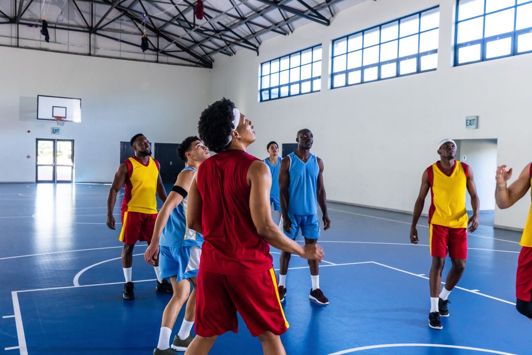Diverse Basketball Players Competing for Rebound in Gym