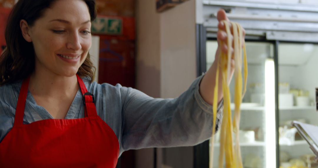 Smiling Woman With Fresh Pasta in Kitchen - Free Images, Stock Photos and Pictures on Pikwizard.com