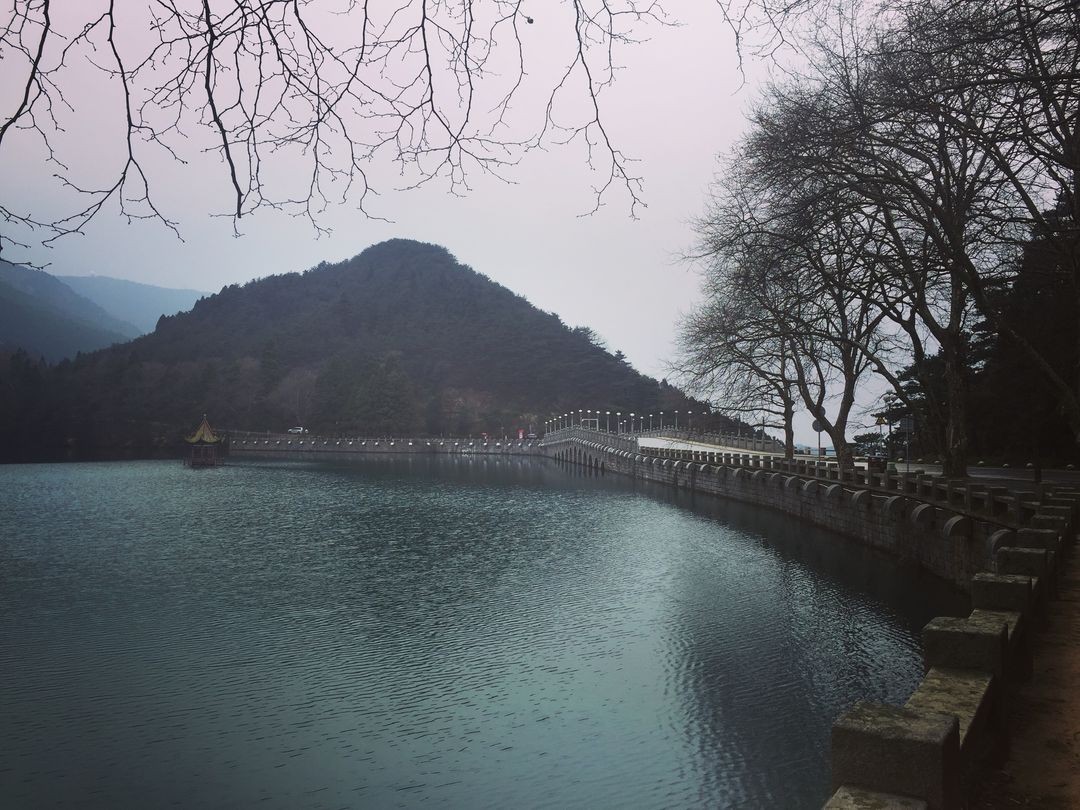 Serene Mountain Lake with Bridge on Cloudy Day - Free Images, Stock Photos and Pictures on Pikwizard.com