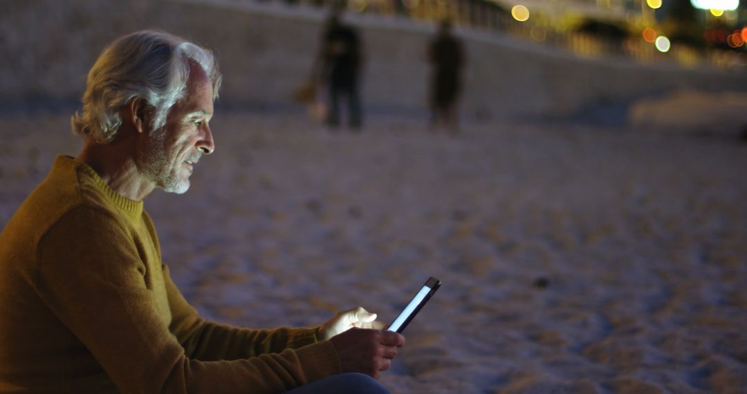 Senior Man Using Tablet on Beach in Evening - Free Images, Stock Photos and Pictures on Pikwizard.com