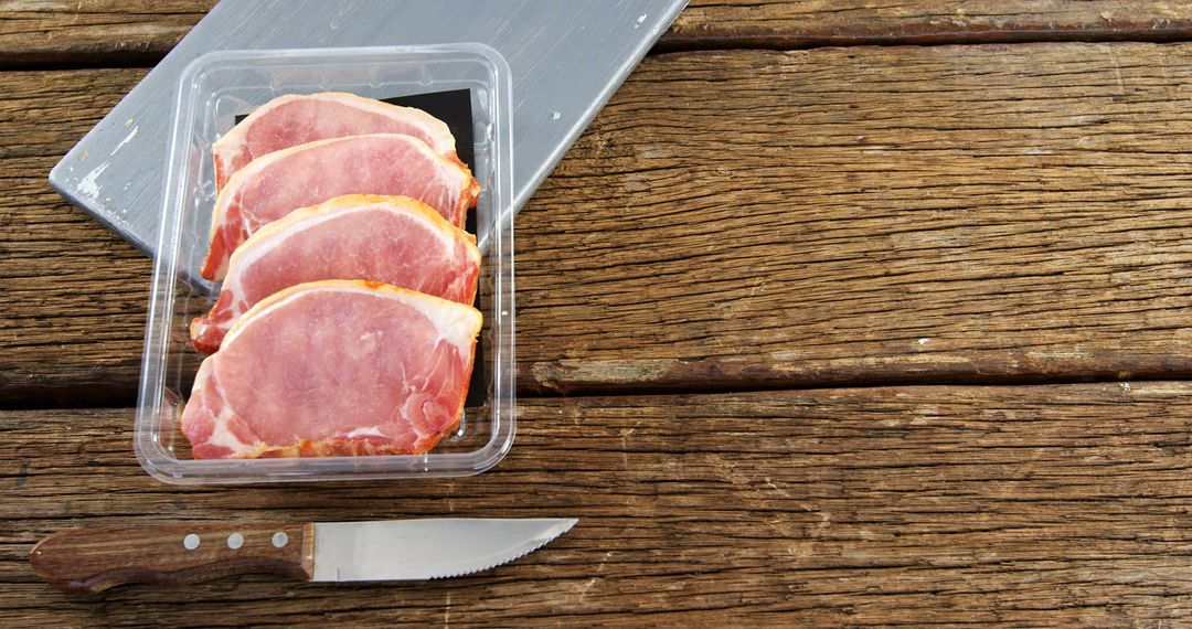 Packaged Pork Loin on Rustic Wooden Table with Knife Nearby - Free Images, Stock Photos and Pictures on Pikwizard.com