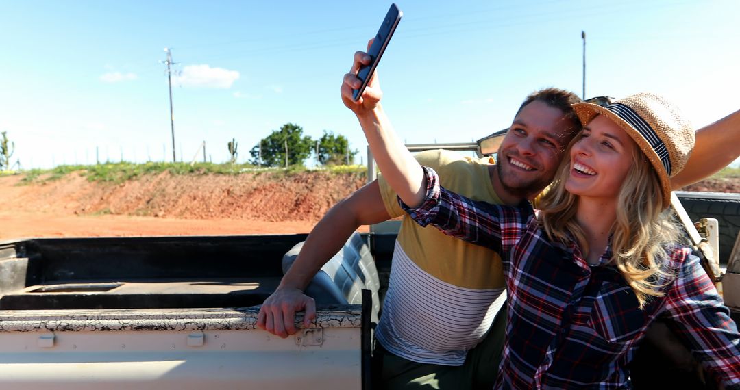 Joyful Couple Taking Selfie in Rural Setting on a Sunny Day