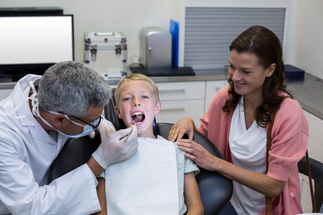 Dentist Examining Young Patient with Mother Present - Free Images, Stock Photos and Pictures on Pikwizard.com
