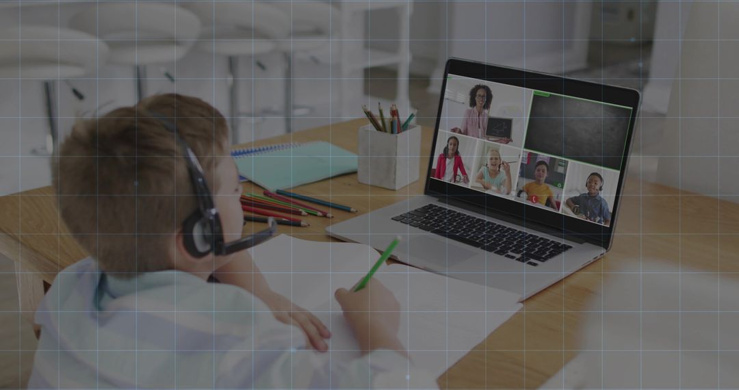 Elementary student learning remotely on laptop with headset and virtual classroom