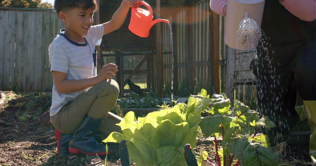 Child and Adult Watering Plants Together in Garden - Free Images, Stock Photos and Pictures on Pikwizard.com