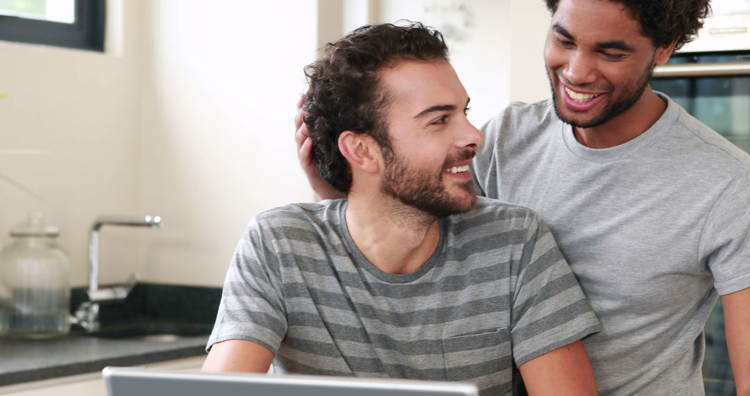 Two Friends Smiling with Laptop at Home