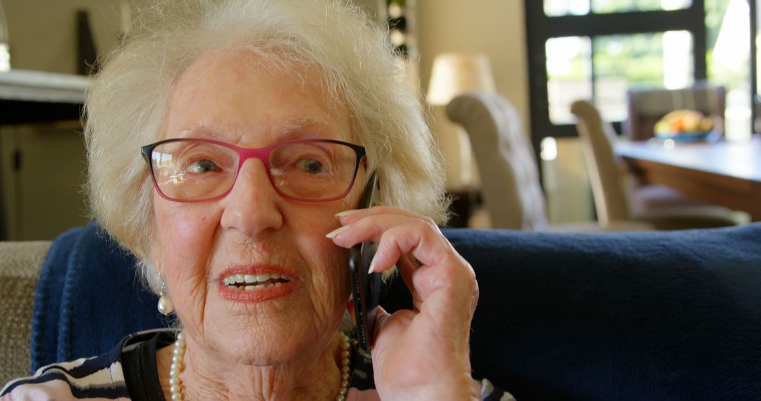 Smiling Elderly Woman Talking on Smartphone at Home - Free Images, Stock Photos and Pictures on Pikwizard.com