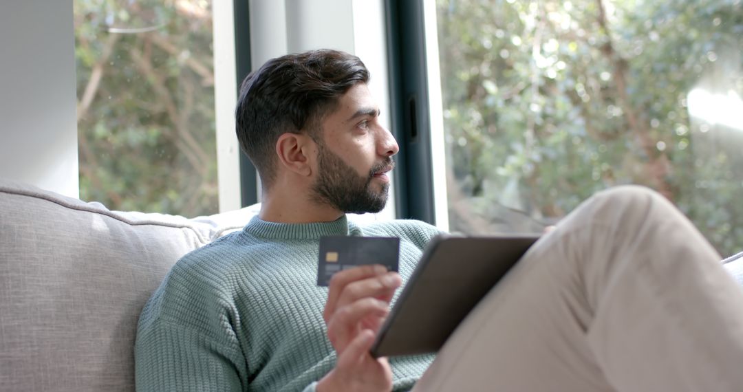 Man Relaxing on Sofa with Tablet and Credit Card - Free Images, Stock Photos and Pictures on Pikwizard.com