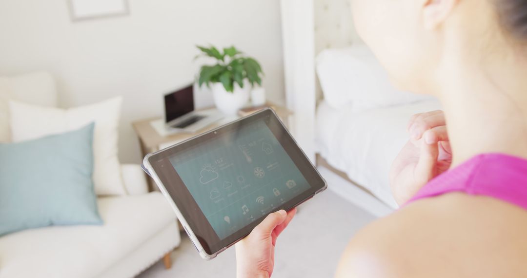 Woman Using Tablet for Smart Home Control in Modern Living Room - Free Images, Stock Photos and Pictures on Pikwizard.com