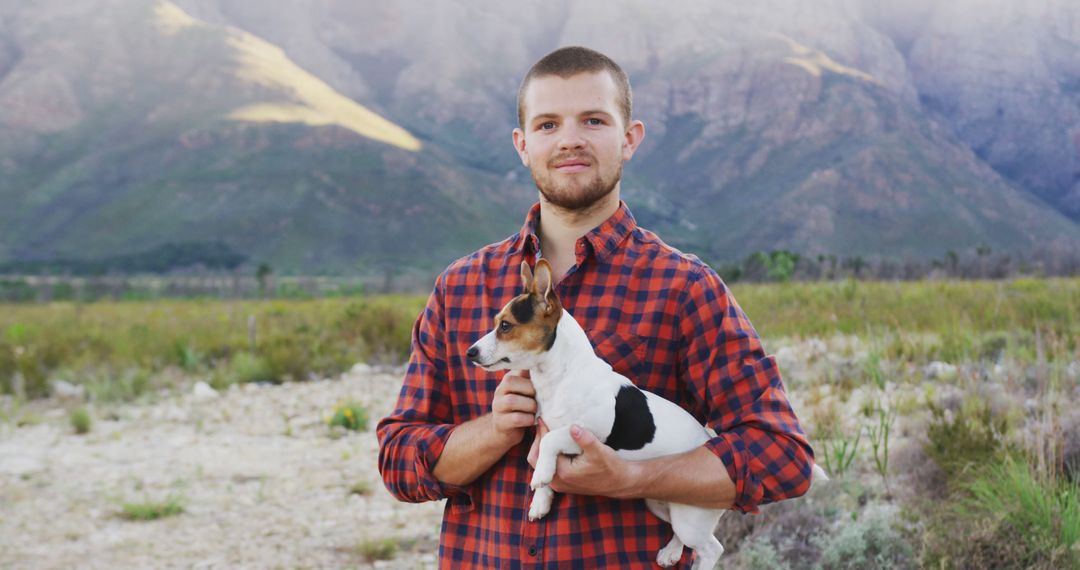 Young Man in Plaid Holding Small Dog in Nature - Free Images, Stock Photos and Pictures on Pikwizard.com