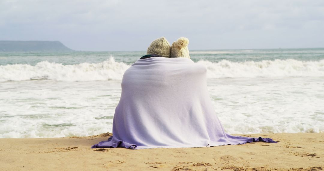 Couple Wrapped in Blanket by Ocean Watching Waves - Free Images, Stock Photos and Pictures on Pikwizard.com