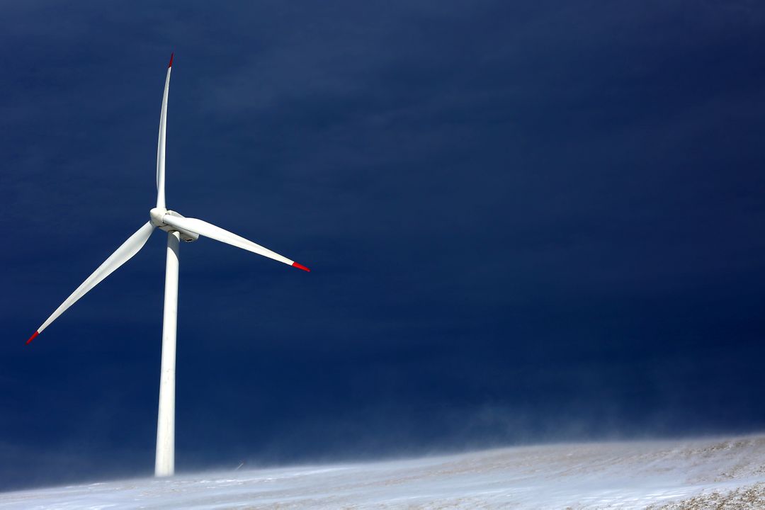 Wind Turbine in Snow-Covered Landscape Under Dark Sky - Free Images, Stock Photos and Pictures on Pikwizard.com